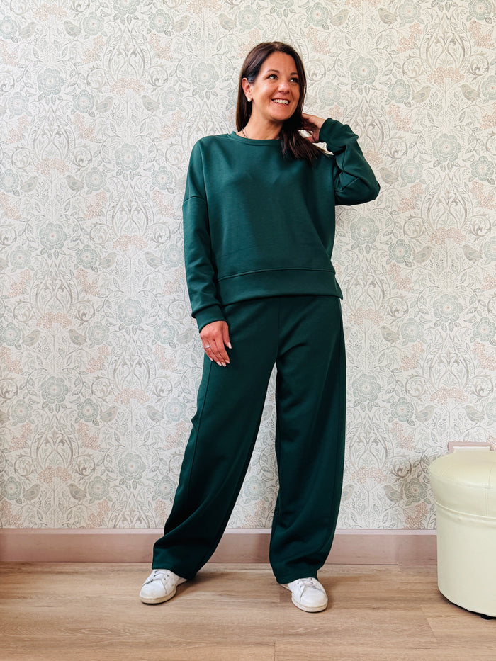 Completo composto da: Pantaloni con elastico in vita, taglio baggy e tasche sui fianchi. Felpa con scollo tondo ampia, svasata e con spacchetti laterali. 