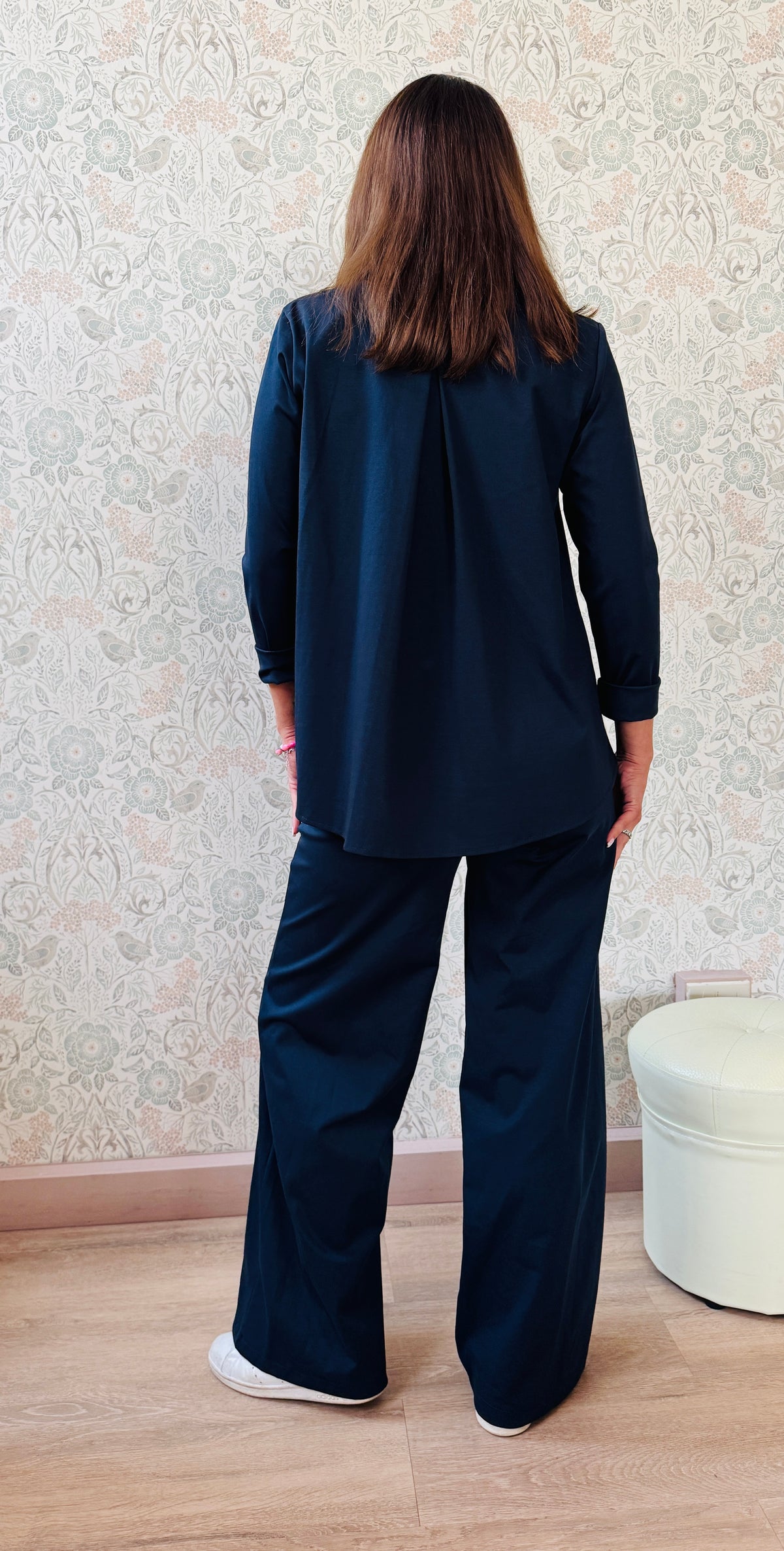 Completo composto da pantaloni con chiusura con zip e cerniera ed elastico sul retro. Taglio a palazzo. Felpa con scollo tondo dal taglio ampio e svasato. 