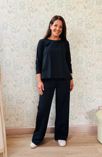 Completo composto da pantaloni con chiusura con zip e cerniera ed elastico sul retro. Taglio a palazzo. Felpa con scollo tondo dal taglio ampio e svasato. 
