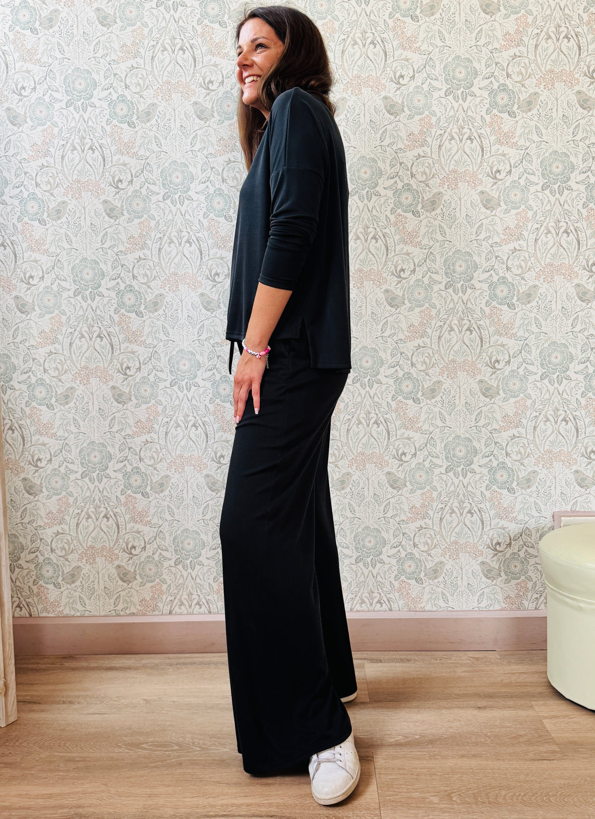 Completo a costine sottili: pantaloni taglio palazzo ampi, elastico in vita, tasche laterali; maglia scollo a barchetta, maniche lunghe e spacchetti laterali 