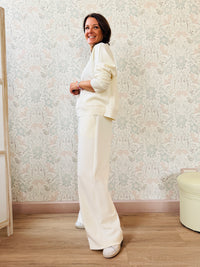 Completo da donna composto da pantaloni ampi con elastico in vita sul retro e tasche laterali; felpa con scollo tondo, manica lunga e spacchetti laterali. 