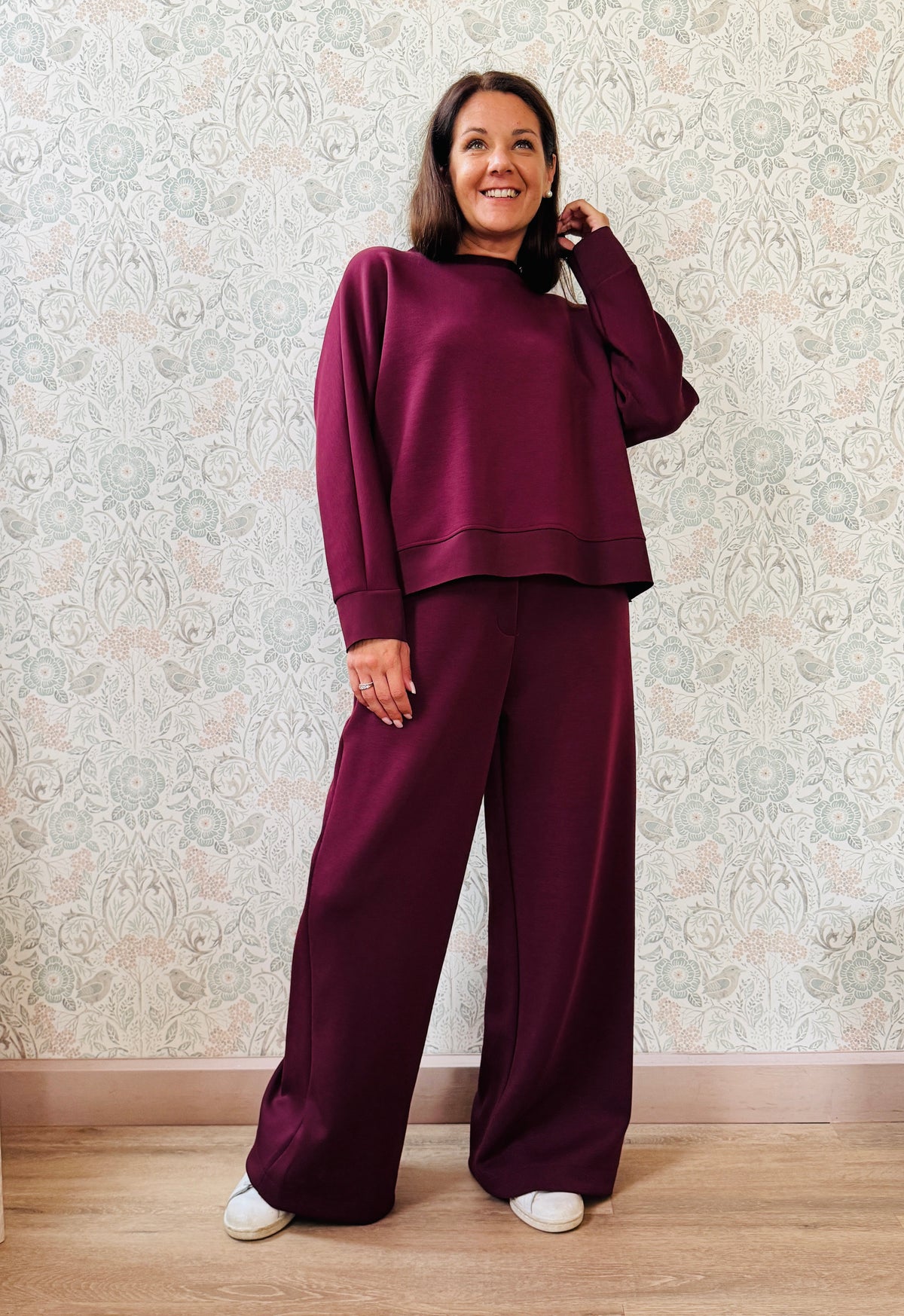 Completo da donna composto da pantaloni ampi con elastico in vita sul retro e tasche laterali; felpa con scollo tondo, manica lunga e spacchetti laterali.  