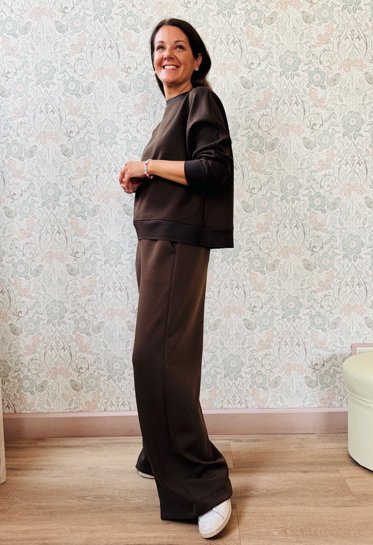 Completo da donna composto da pantaloni ampi con elastico in vita sul retro e tasche laterali; felpa con scollo tondo, manica lunga e spacchetti laterali. 