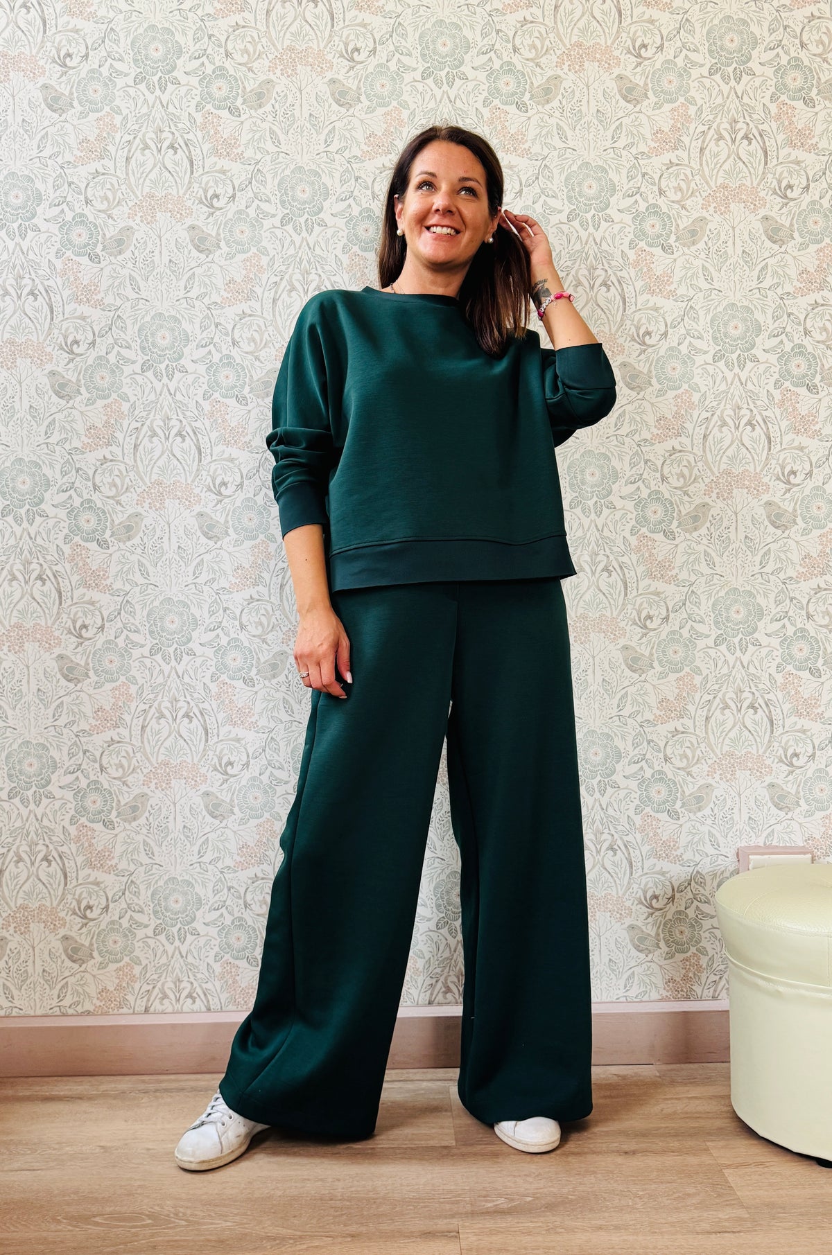 Completo da donna composto da pantaloni ampi con elastico in vita sul retro e tasche laterali; felpa con scollo tondo, manica lunga e spacchetti laterali. 